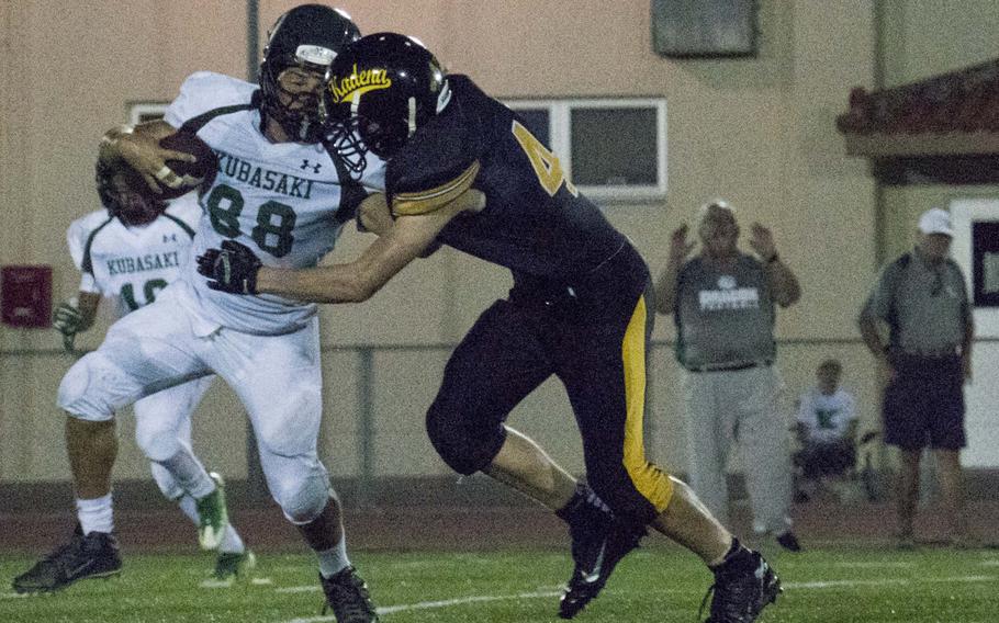 Kadena's Braydon Frederick tries to wrap up Kubasaki's Omar Garcia in the Panthers' 47-20 victory over the Dragons on Thursday.