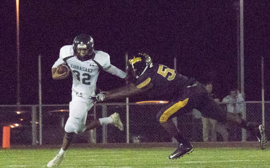 Kubasaki's Anthony Macaluso tries to avoid Kadena's Tyler Lewis in the Panthers' 47-20 victory Thursday over the Dragons.