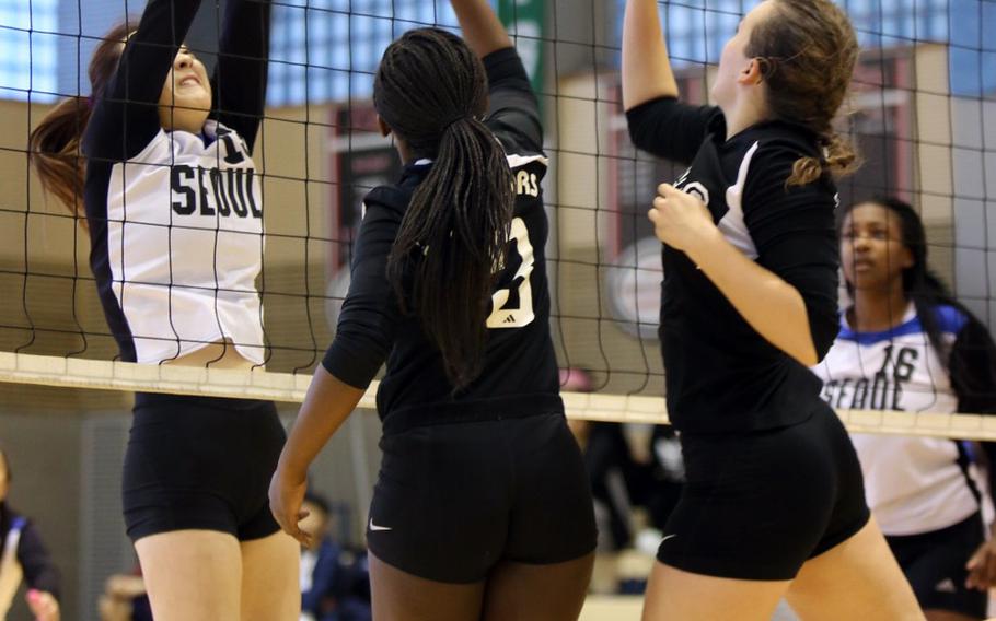 Stephanie Choe of Seoul American tries to block a shot by Sarah Spavins and Catherine Christine of Daegu during Monday's quarterfinal match. The Falcons won 25-9, 25-6, 25-9.