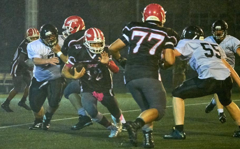 Kinnick quarterback Kacee Walker escapes a collapsing pocket during the second half of the Red Devils' 45-6 homecoming victory over Zama on Friday, Oct. 28, 2016 at Naval Base Yokosuka, Japan. Walker led all rushers with 150 yards on 11 carries. 