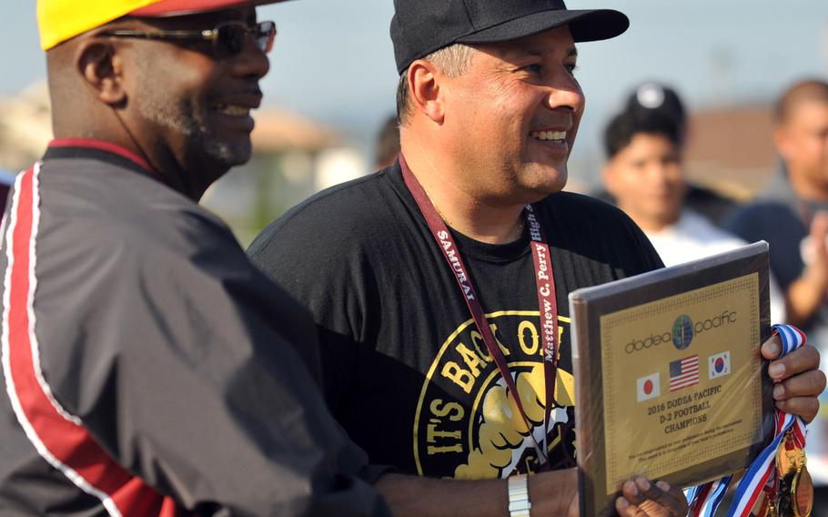 Perry principal Lorenzo Brown and coach Frank Macias display the championship plaque and medals.