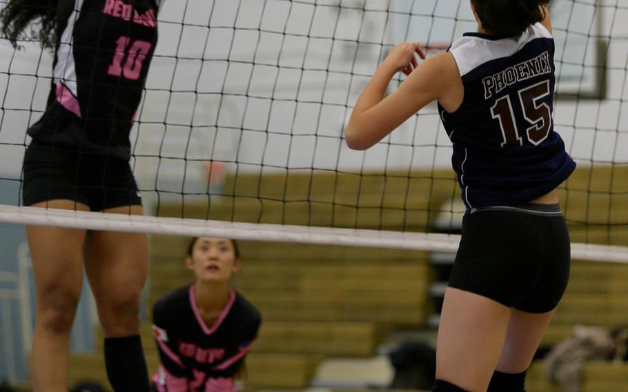 Nile C. Kinnick's Stephanie Stockman blocks a shot by Seisen's Amanda Wood during Tuesday's round-robin play in the Far East Division I volleyball tournament. The Red Devils outlasted the Phoenix in three sets, 25-19, 28-30, 25-19.