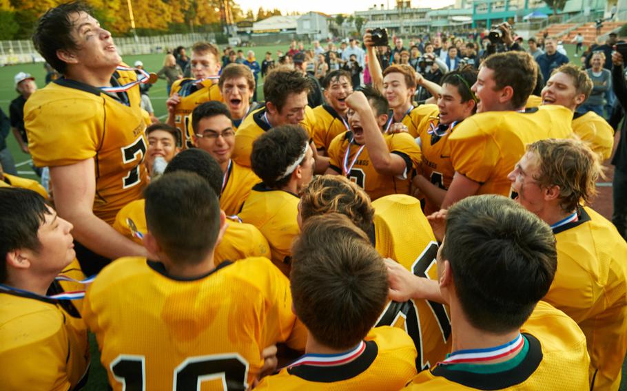 The ASIJ Mustangs celebrate following the Far East Division I Football Championship on Saturday at the American School in Japan in Chofu, Japan. ASIJ defeated Kadena 35-18 to claim its first Far East Football crown. 