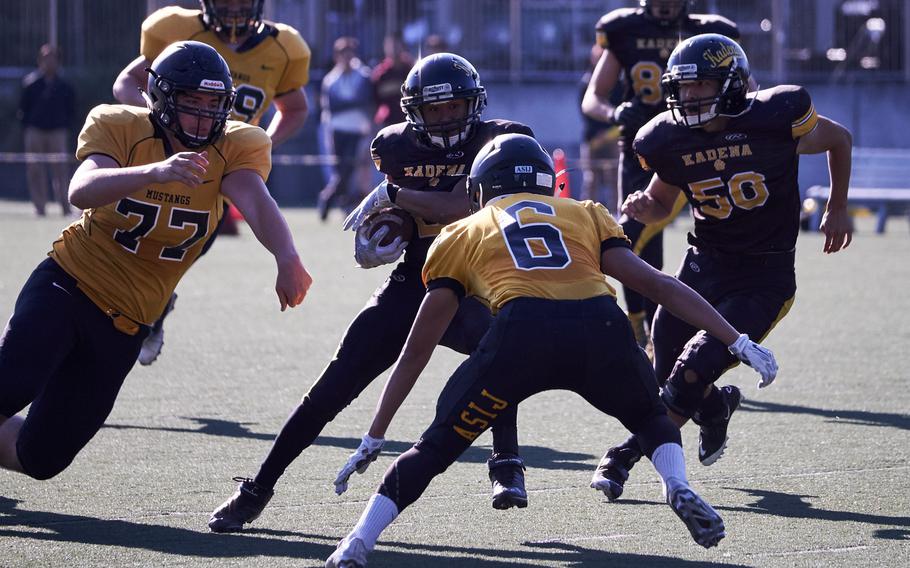 Kadena's Jericho Williams cuts upfield as ASIJ's Sho Hatakeyama and Dalan Gerber, left, defend during the first quarter of the Far East Division I Football Championship on Saturday at the American School in Japan in Chofu, Japan. ASIJ defeated Kadena 35-18 to claim its first Far East Football crown. 