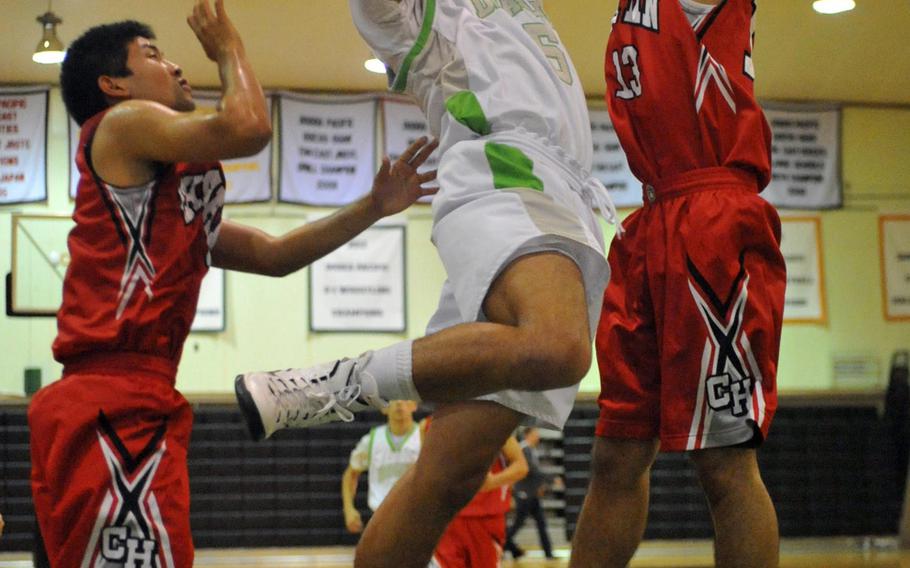 Kubasaki senior Bobby Riegert drives between defenders for a shot Friday during the Dragons' 86-59 season-opening home win over Chatan.