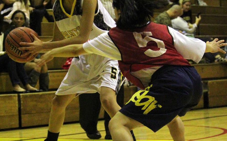 Kadena Panthers guard Valeria Robles looks for operating room against a Futenma Red Braves defender during Monday's girls basketball game. Defending Far East Division I Tournament champion Kadena fell 54-44.