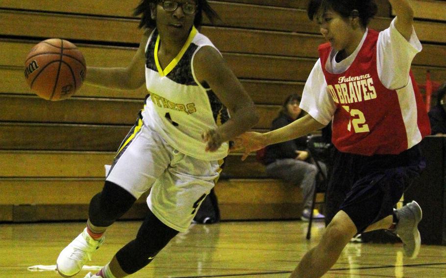 Kadena Panthers guard Rhamsey Wyche dribbles against a Futenma Red Braves defender during Monday's girls basketball game. Wyche, the reigning Far East Division I Tournament Most Valuable Player, had 15 points in a losing effort as defending champion Kadena fell 54-44.