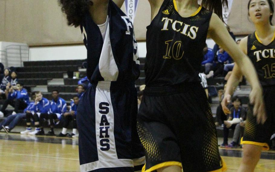 Seoul American's Alexandra Easterling tries to shoot over Taejon Christian's Sylvia Yun duriing Friday's girls basketball game, won by the Falcons 41-26.