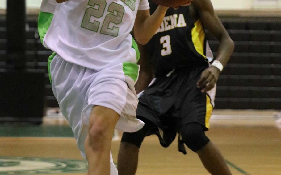 Kubasaki's Elonzo Higginson III drives to the basket ahead of Kadena's K.J. Caver during Friday's boys basketball game. The Panthers beat the two-time defending Far East Division I champion Dragons 71-67.