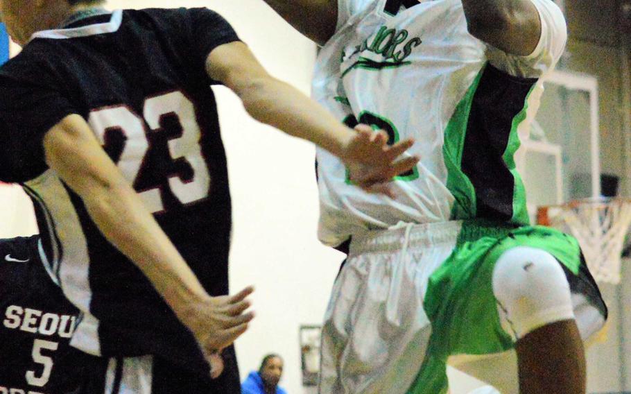 Keith Williams of Daegu skies for a shot past Seoul Foreign's Nick Larsen during Friday's boys basketball game, won by the Crusaders 55-50.