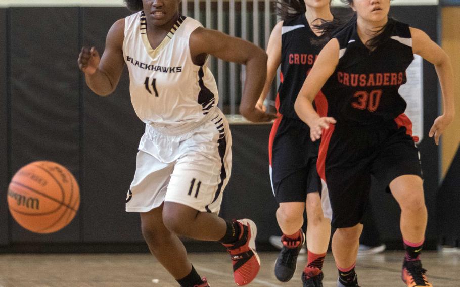 Humphreys' Myah Childs chases the ball against Seoul Foreign's Tabitha Kim during Saturday's girls basketball game, won by the Crusaders 32-27.