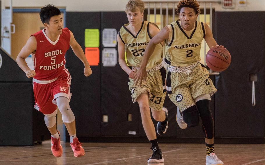 Humphreys' Tyrell Alexander breaks up the court, escorted by teammate Jackson Taylor, against Seoul Foreign's Paul Yoon during Saturday's boys basketball game, won by the Blackhawks 54-51.