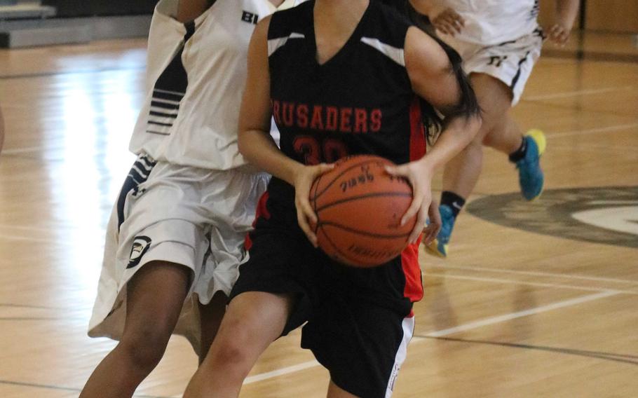 Seoul Foreign's Tabitha Kim tries to shoot against Humphreys' Tyra Harris during Saturday's girls basketball game, won by the Crusaders 32-27.