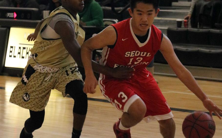 Seoul Foreign's Brandon Sohn tries to dribble past Humphreys' Da'Shun Cline during Saturday's boys basketball game, won by the Blackhawks 54-51.