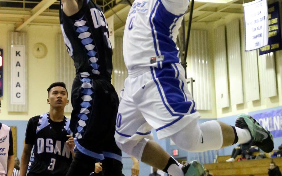 Seoul American's Ken Paclipan puts up a shot against Osan's Matthew Burbee during Wednesday's boys basketball game, won by the Falcons 60-37.