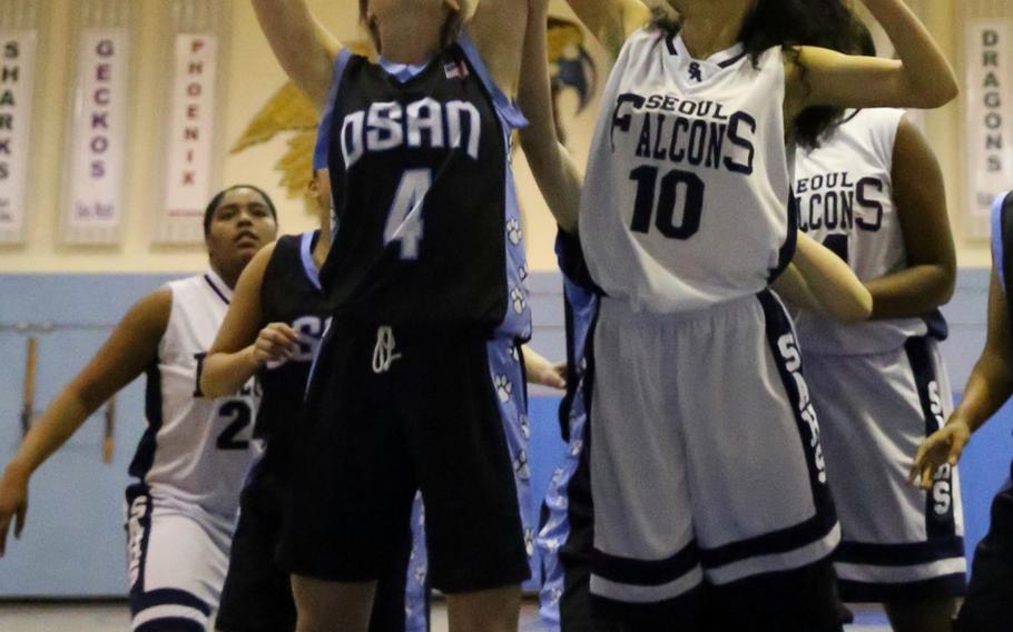 Osan's Haille Nugent and Seoul American's Brinkley Garner fight for a rebound during Wednesday's girls basketball game. The Falcons won 39-32.