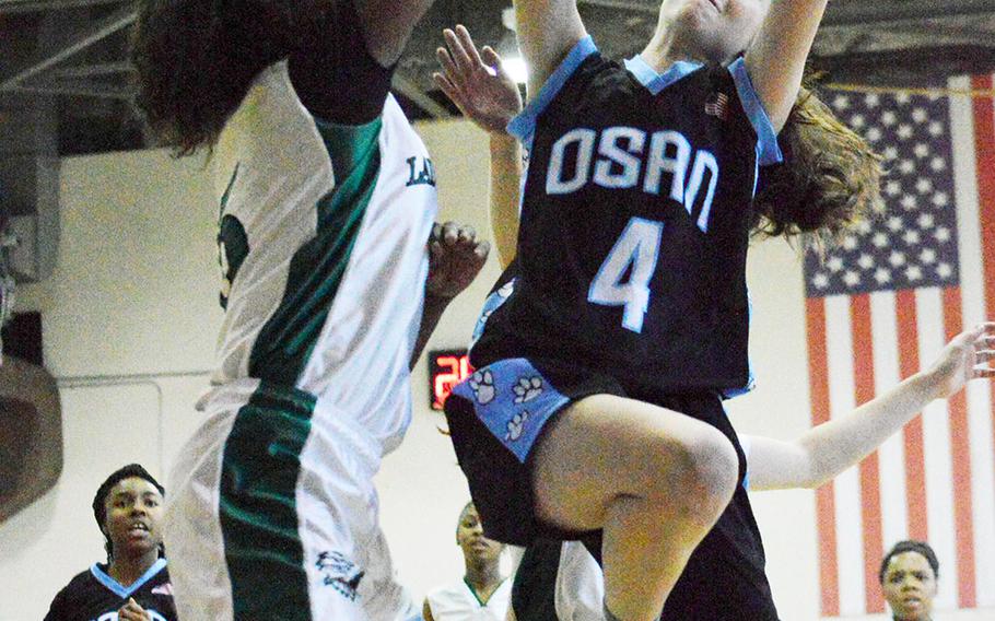 Kennedi Williams of Daegu defends against Osan's Haille Nugent during Thursday's girls basketball game, won by the Cougars 45-8.