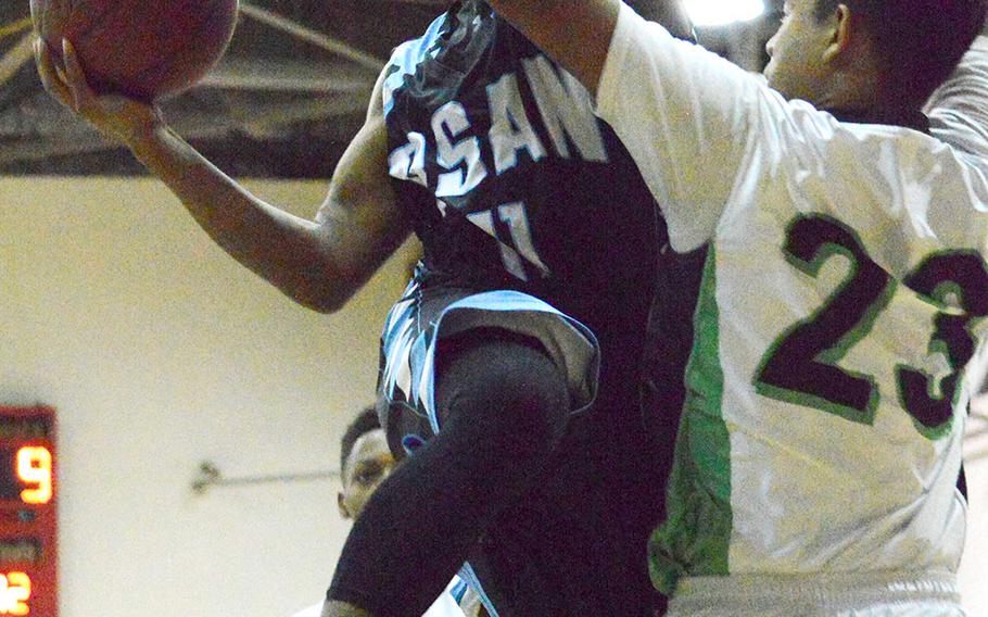 Osan's Micah Butler goes up for a shot against Daegu's Samuel Murphy during Thursday's boys basketball game, won by the Warriors 54-40.