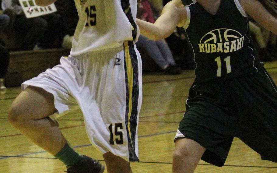 Kadena's Linda Vaughan drives to the basket ahead of Kubasaki's Chloe' Stevens during Thursday's girls basketball game.