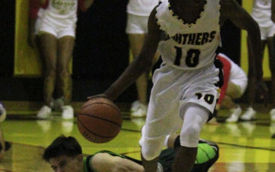 Kadena's K.J. Caver drives upcourt, leaving Kubasaki's Bobby Riegert on the floor during Thursday's boys basketball game. 