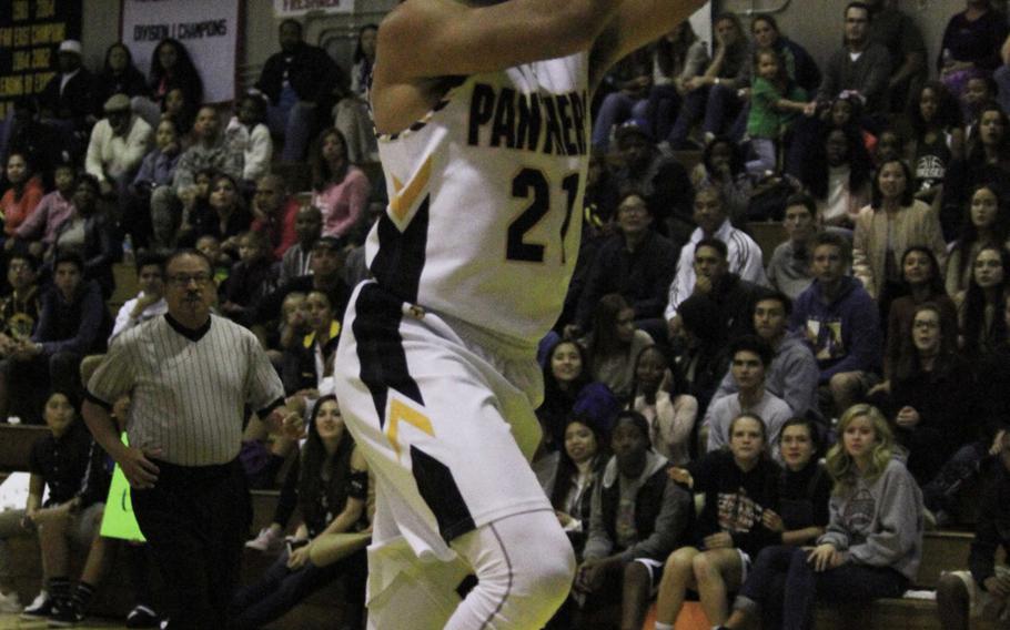 Kadena's Justin Wlson drives to the basket against Kubasaki during Thursday's boys basketball game. The Panthers rallied to win 58-52, beating the two-time defending Far East Division I champion Dragons for the second time this season.
