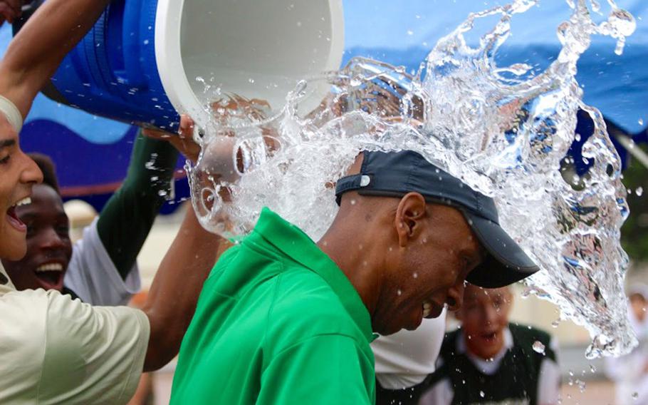Kubasaki coach Tony Washington gets the water-bucket treatment from his Division I Tournament-champion players. It took the Dragons four tries in five years, but they finally got that long-sought Division I Tournament title, blanking Christian Academy Japan 2-0.