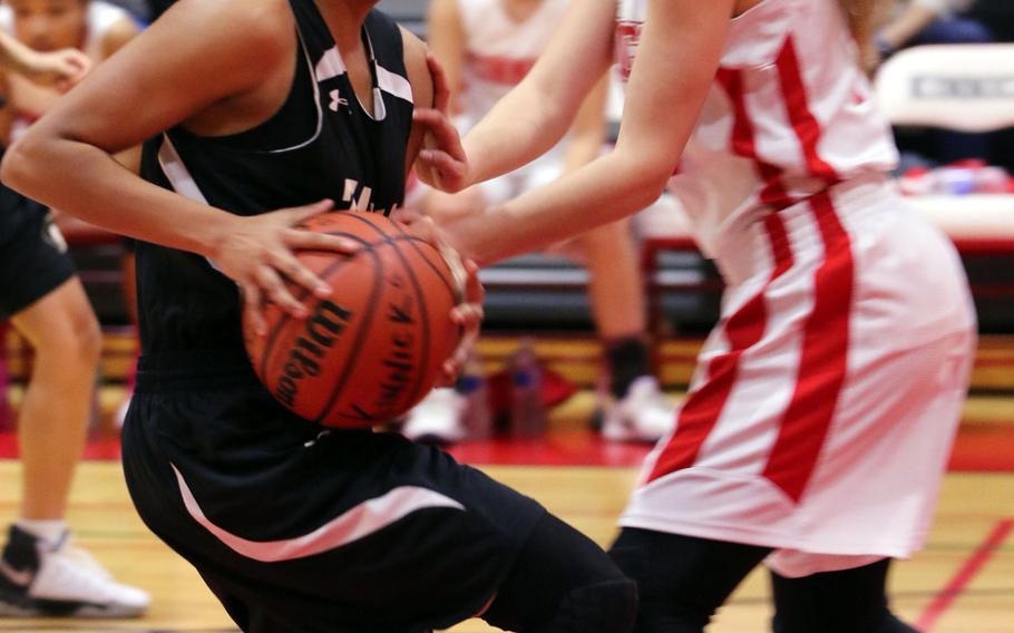 Zama's Ti'Ara Carroll gets tied up by Nile C. Kinnick's Kailee Rucker during Wednesday's girls basketball game. The Division II Trojans edged the D-I Red Devils 35-31 in overtime.