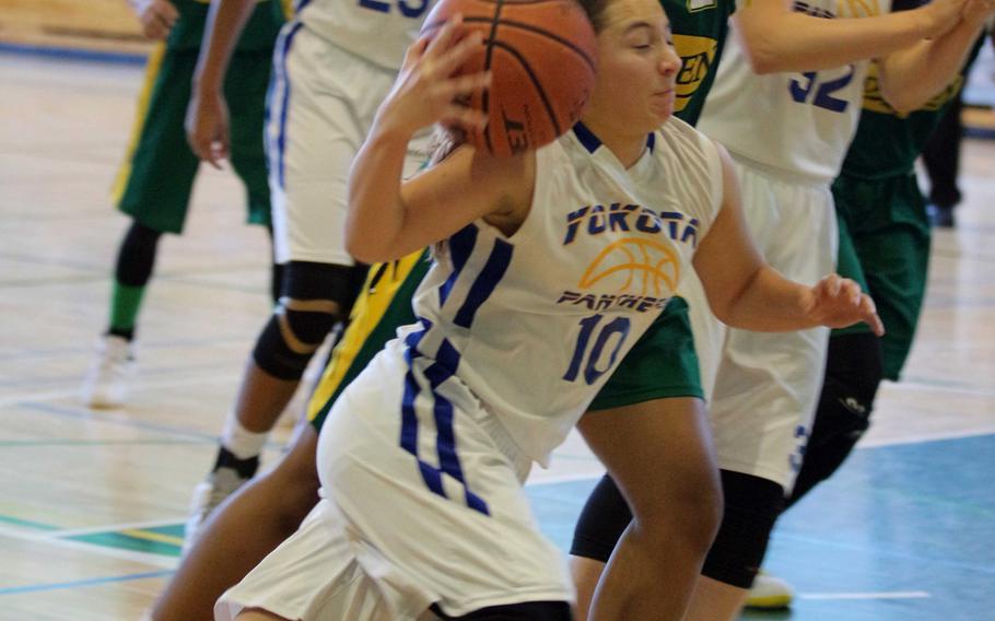 Yokota's Taylor Peche tries to keep a handle on the ball against Robert D. Edgren's Christina Taylor during Saturday's girls basketball game, won by the Panthers 50-40.