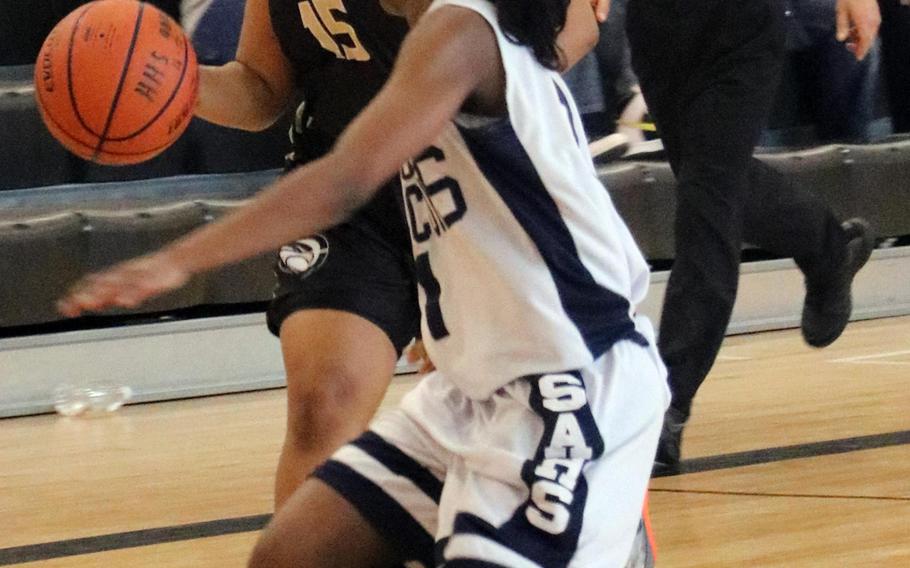 Humphreys' Naomi Harris dribbles against Seoul American's Alysa Neal during Saturday's girls basketball game. The Blackhawks got their first win in the school's four-year history over the Falcons, 40-37.