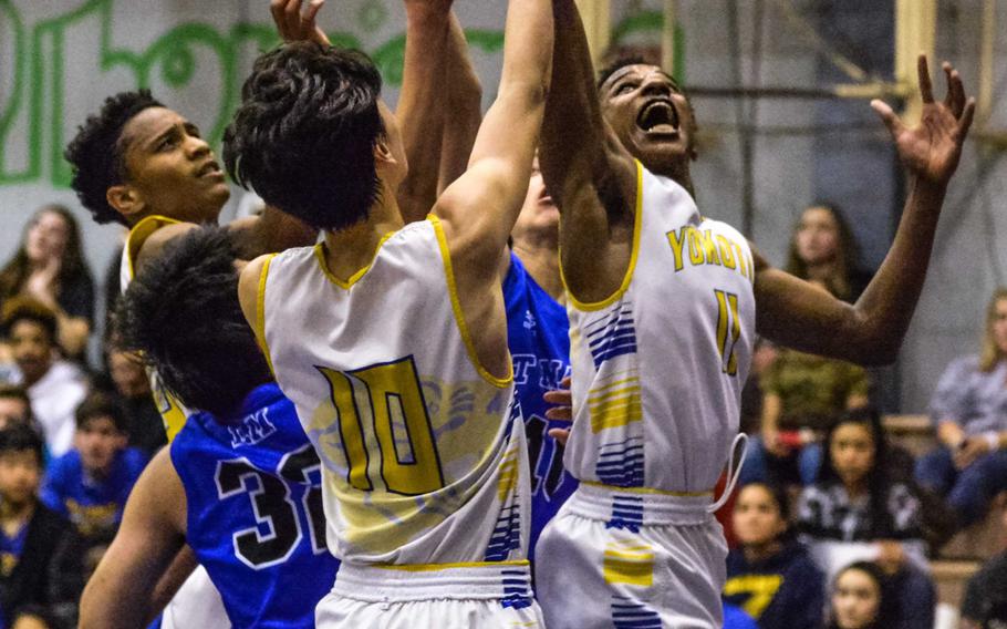 Yokota's Kishaun Kimble-Brooks skies for a rebound amid a sea of teammates and St. Mary's defenders during Tuesday's boys basketball game, won by the Panthers 63-45.