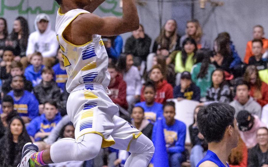 Yokota's Marquis Smith-Brown skies for a shot over St. Mary's Jongdae Kim during Tuesday's boys basketball game, won by the Panthers 63-45.