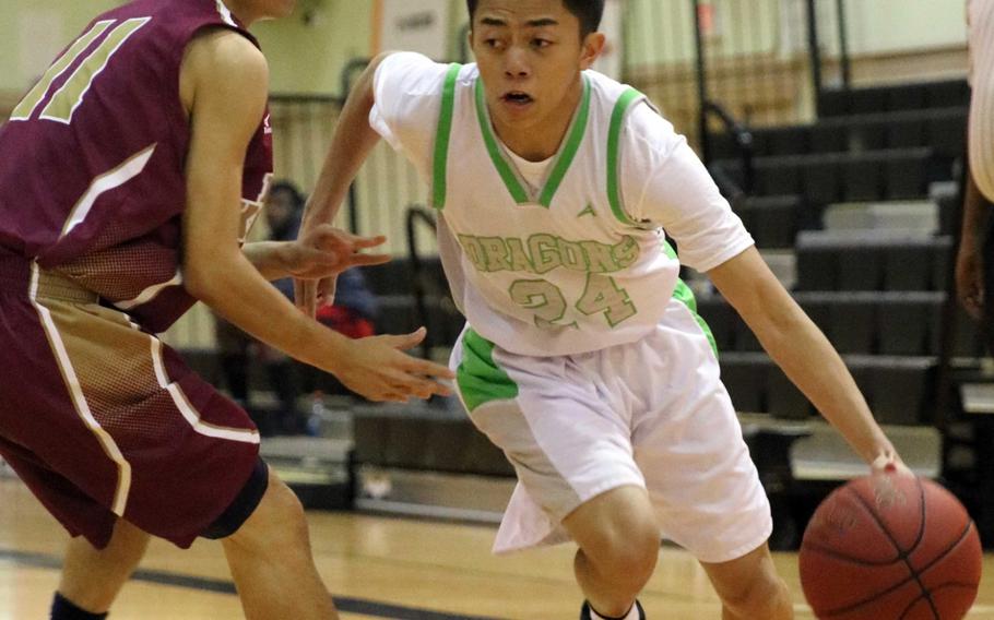 Kubasaki's Jhean Natividad dribbles against a Naha Kokusai defender during Wednesday's boys basketball game, won by the Dragons 72-69 in overtime.