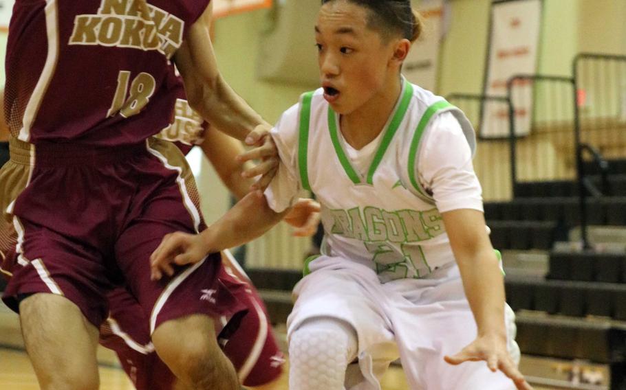 Kubasaki's Dylan Canlas dribbles against a Naha Kokusai defender during Wednesday's boys basketball game, won by the Dragons 72-69 in overtime.
