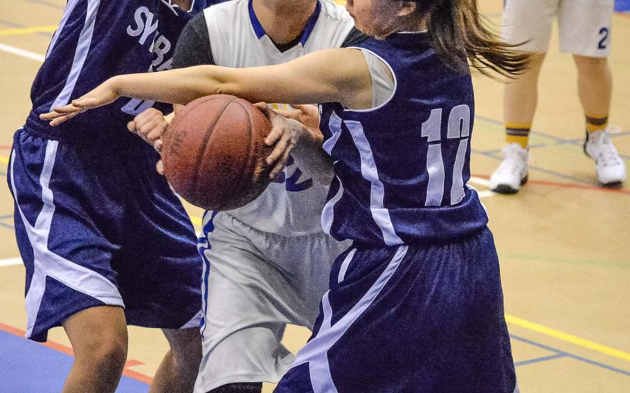 Yokota's Irene Diaz tries to drive between Sacred Heart's Alisa Belitz and Lisa Sato during Thursday's girls basketball game, won by the Panthers 59-19.