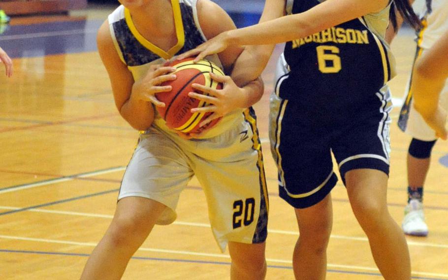 Kadena's Yasmine Doss and Morrison Academy of Taiwan' Juri Yanamoto tie up for the ball during Friday's girls game in the 2nd Taipei American School Basketball Exchange. The defending Far East Division I Tournament champion Panthers won 63-46.