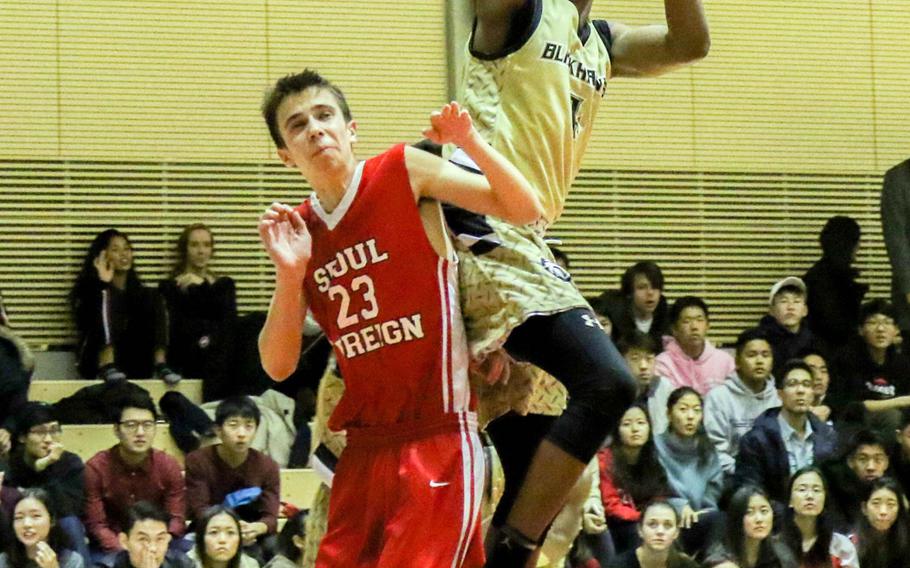 Humphreys' Nate Hellams skies for a shot over Seoul Foreign's Nick Larson during Friday's Korea boys basketball game, won by the Blackhawks 53-49; they took over first place in the Korea Blue Division. Hellams had 22 points and 12 rebounds.