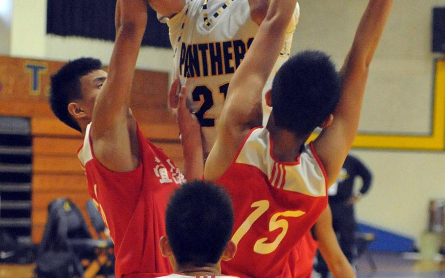 Kadena's Justin Wilson skies over three Yilan Senior High School defenders during Saturday's boys game in the 2nd Taipei American School Basketball Exchange. The Panthers lost for the first time in six games they've played in Taipei, 80-77 to Yilan, a local Chinese team.