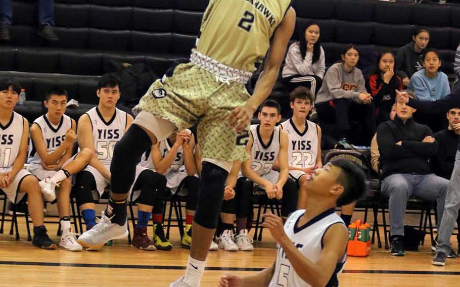 Humphreys' Tyrell Alexander skies for a shot over Yongsan's Max Choi during Saturday's 76-37 win by the Guardians over the host Blackhawks in Korea Blue boys basketball.