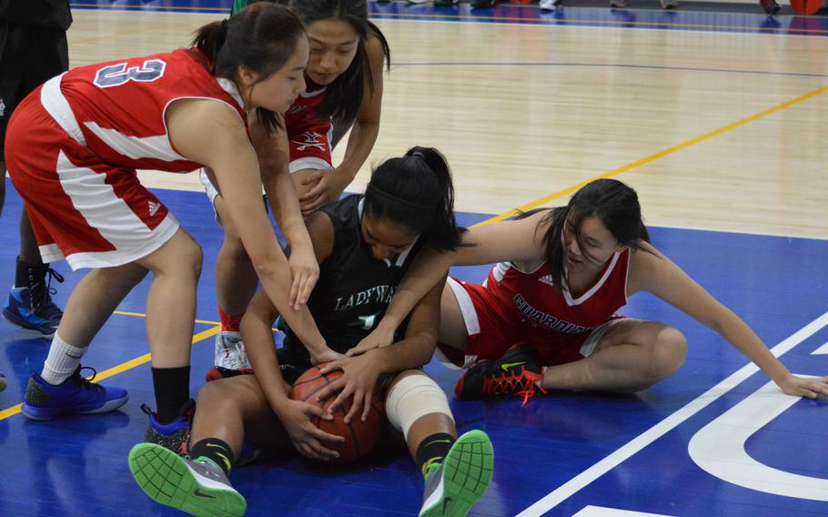 Daegu's Kamala Kenny finds herself and the ball tied up by Yongsan's Gayoon Choi, Rebecca Kim and Amelia Tang during Saturday's girls basketball game, won by the Guardians 38-4.