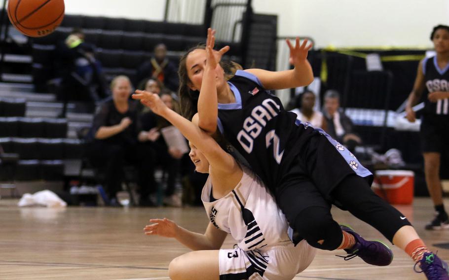 Osan's Christina Britt and Humphreys' Hayden Orr collide in a chase for the ball during Wednesday's girls basketball game. The visiting Cougars won 51-25.