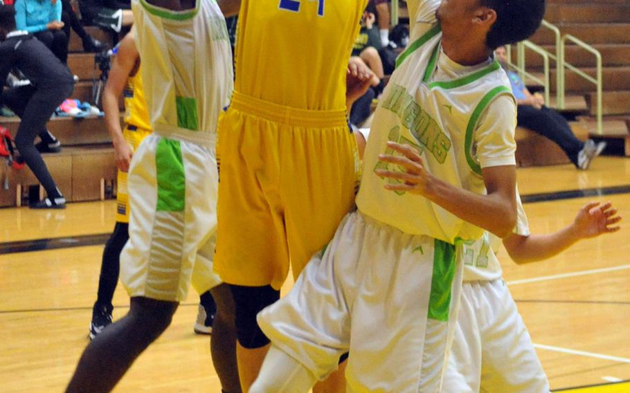 Yokota's Renyck Robertson finds himself surrounded by Kubasaki defenders Xavier Carmouche, Ilijah Washington and Dylan Canlas in a battle of two-time defending Far East Tournament champions on Day 2 Friday of the 1st ASIJ Kanto Classic. The Division II Panthers downed the Division I Dragons 50-35 and earned the top seed in Saturday's single-elimination playoffs.