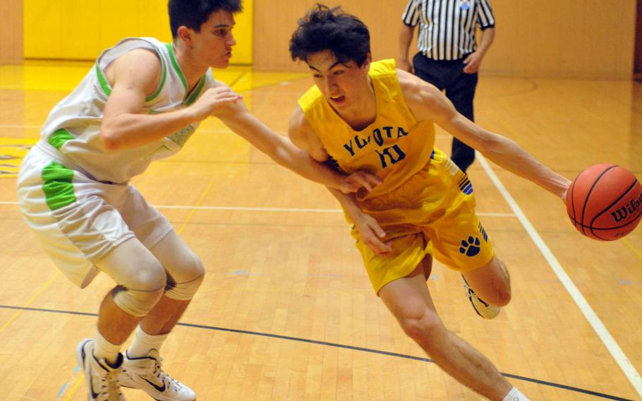 Yokota's Hunter Cort dribbles past Kubasaki's Bobby Riegert in a battle of two-time defending Far East Tournament champions on Day 2 Friday of the 1st ASIJ Kanto Classic. The Division II Panthers and reigning D-II MVP Cort downed the Division I Dragons 50-35 and earned the top seed in Saturday's single-elimination playoffs.