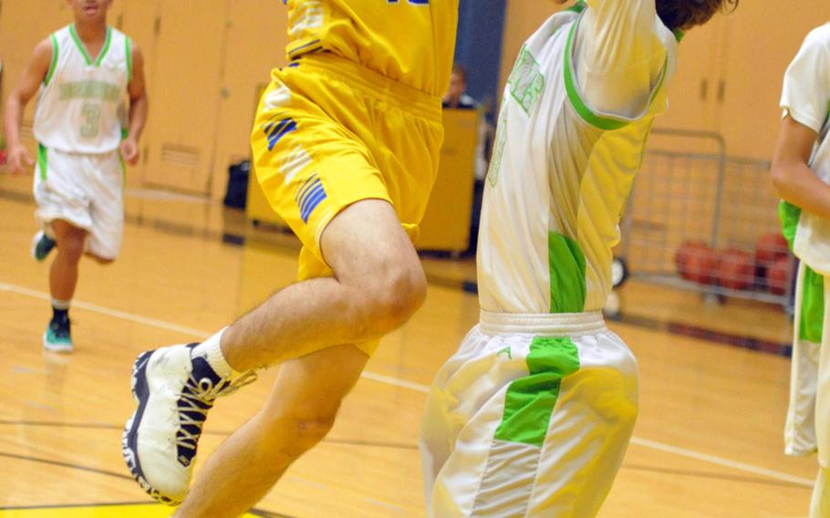 Yokota's Hunter Cort goes up for a shot against Kubasaki's Jonny Hoppe in a battle of two-time defending Far East Tournament champions on Day 2 Friday of the 1st ASIJ Kanto Classic. The Division II Panthers and reigning D-II MVP Cort downed the Division I Dragons 50-35 and earned the top seed in Saturday's single-elimination playoffs.