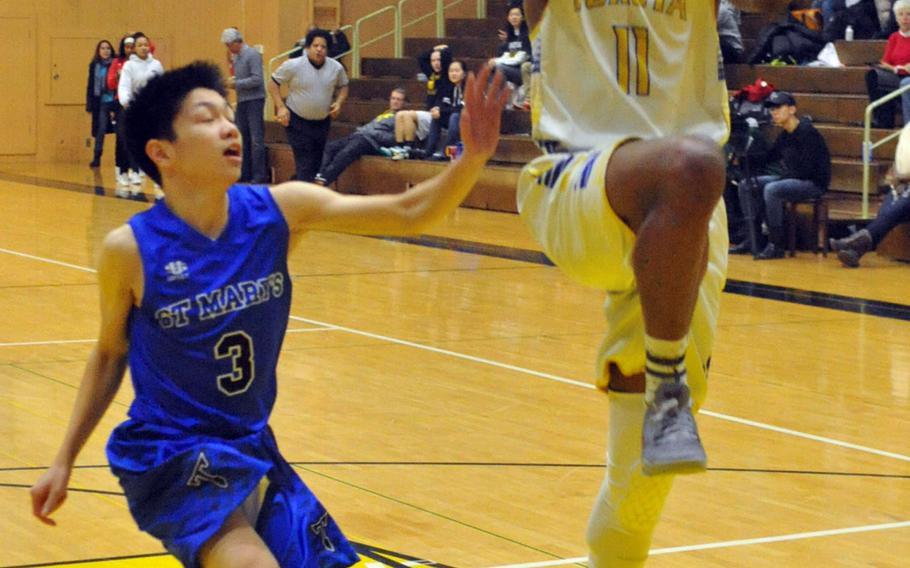 Yokota's Kishaun Kimble-Brooks shoots past St. Mary's Ross Sheng for the first basket of the game during Saturday's boys championship game in the ASIJ Kanto Classic basketball tournament. The Panthers downed the Titans 57-47.