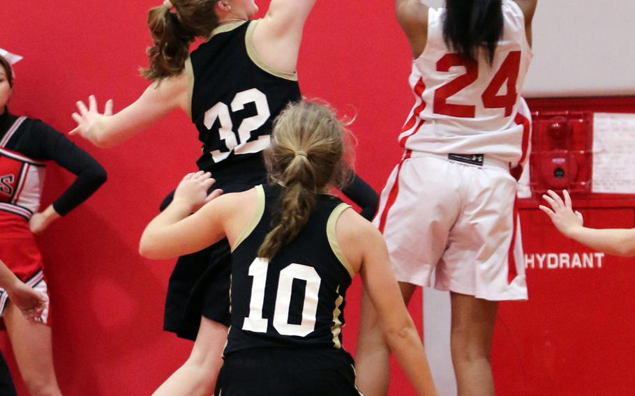 Nile C. Kinnick's Dallas Carter shoots against American School In Japan's Grace Wallrapp during Wednesday's girls basketball game, won by the visiting Mustangs 46-36. It was just the third loss in 20 games for the host Red Devils - two came to the Mustangs.