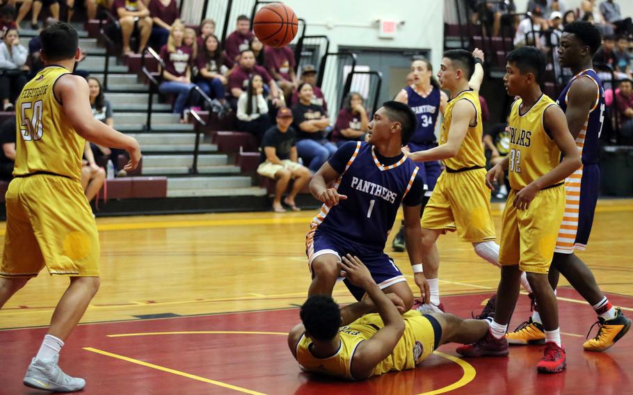 Guam High's Juan King Jr. looks back over his shoulder at a loose ball while surrounded by Father Duenas  players during Saturday's Guam boys game. The Friars downed the Panthers 52-41, just the second loss in seven games for Guam.