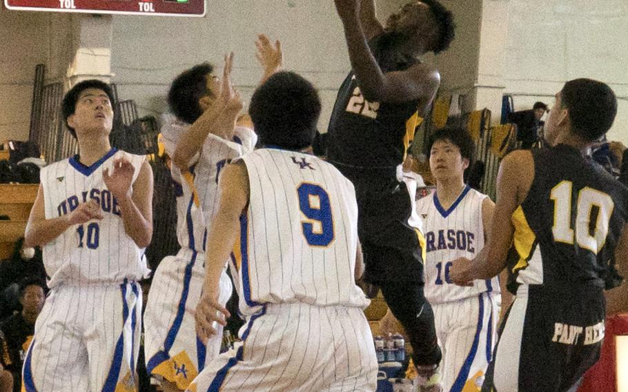 Kadena's Jahron Mitchell leaps high to shoot over Urasoe defenderrs Saturday's pool-play game in the 11th Okinawa-American Friendship Basketball Tournament. The Panthers lost to Urasoe 34-31, then later lost their first-round playoff game and were relegated to Sunday's consolation round.