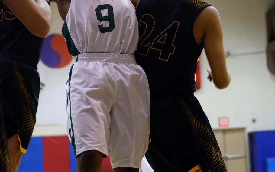 Daegu's Bishop Fields leaps for the ball against Taejon Christian's J.J. Jung during Wednesday's boys basketball game, won by the Warriors 57-50.