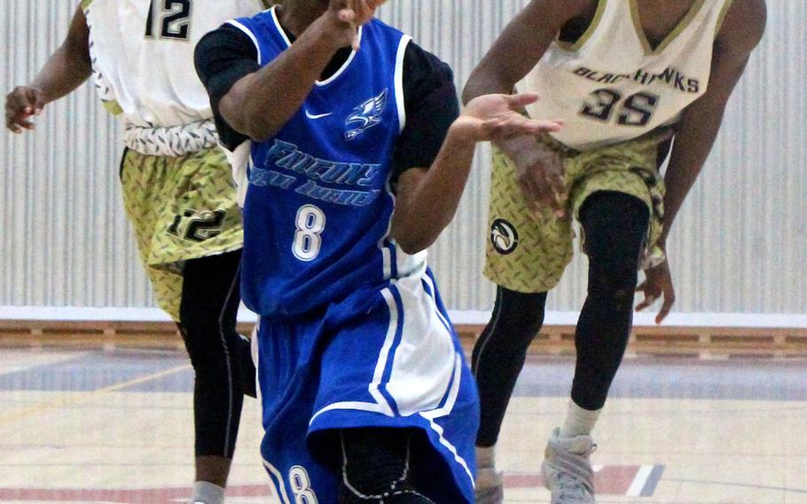 Seoul American's Willie Grandison gathers in the ball in front of Humphreys' Da'Shun Cline and Jalen Hill during Saturday's final of the Korea Blue boys basketball tournament. The Falcons rallied to win 42-38.