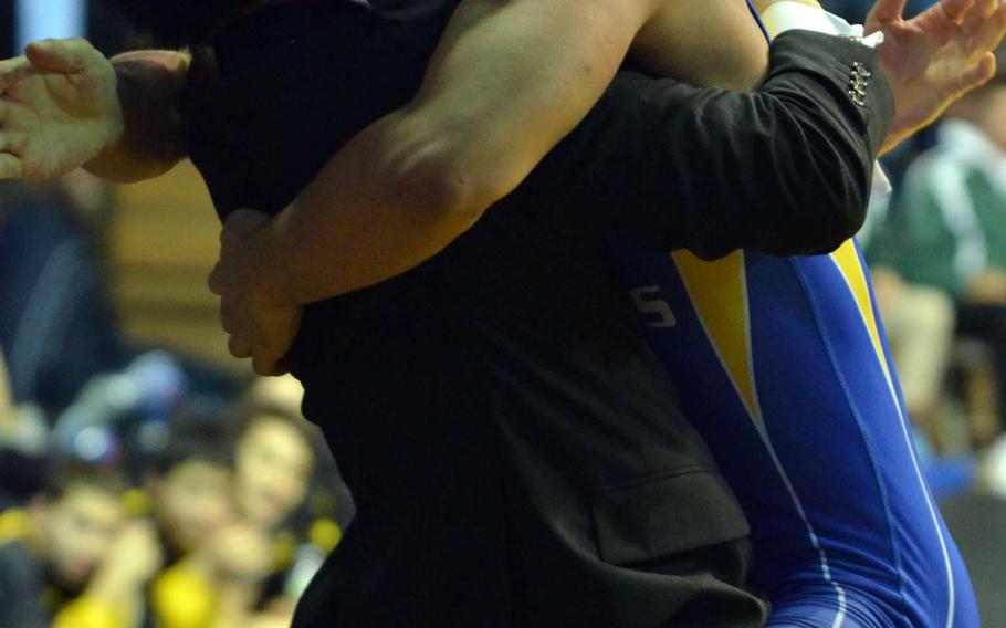 St. Mary's Ryo Osawa hugs his longtime coach Shu Yabui after Friday's 141-pound championship in the Far East High School Wrestling Tournament. Osawa beat Osan's Hunter VanHoose by technical fall 14-3 in 3:28 for his second straight gold medal.